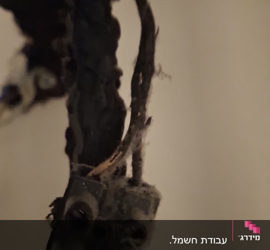 חוטי חשמל ישנים ומאובקים בתקרת חדר
